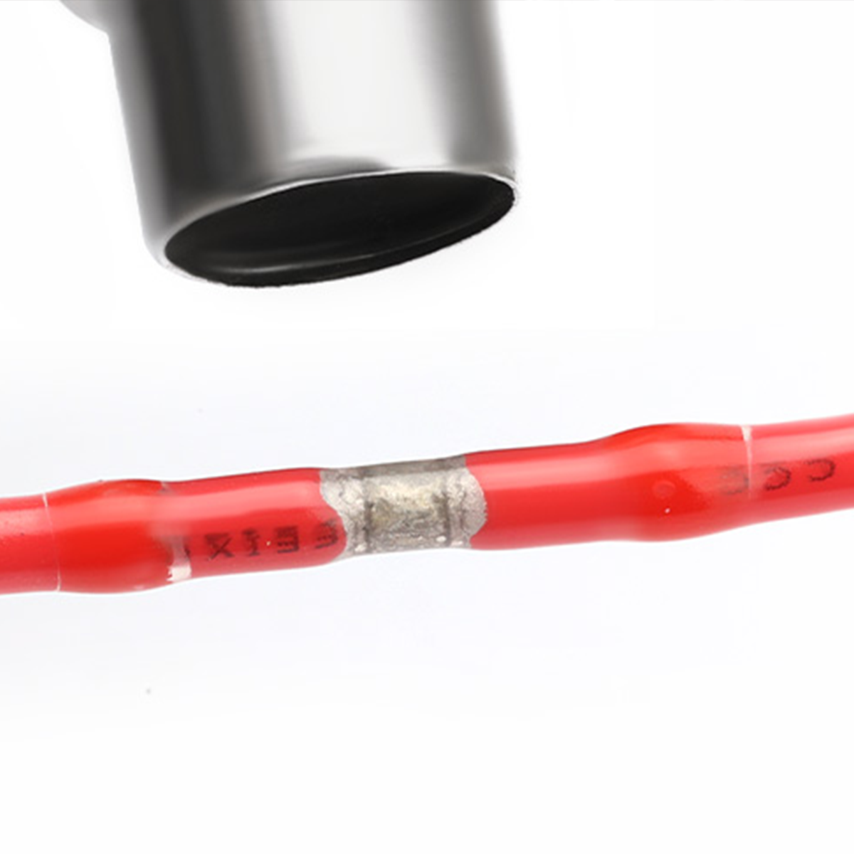 Heat shrink wire connectors with solder on red wire. Silver tool hovering, seamless splice.