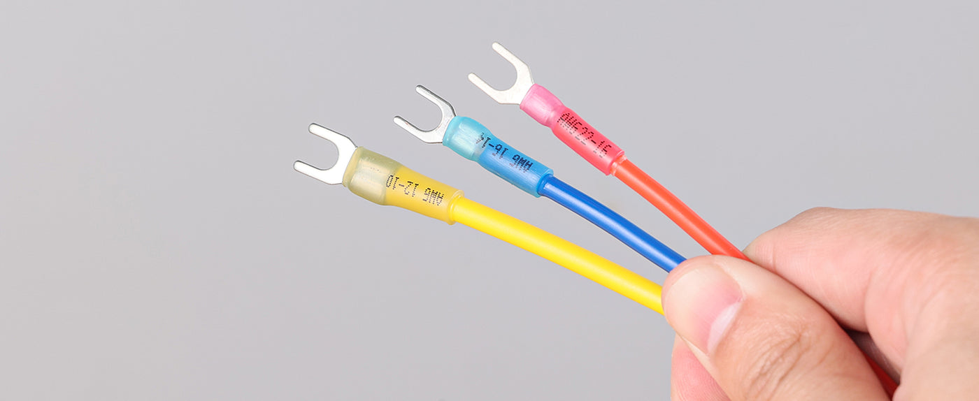 Forked terminals crimped onto color coded wires, designed for quick fastening to screws in low voltage electrical connections.